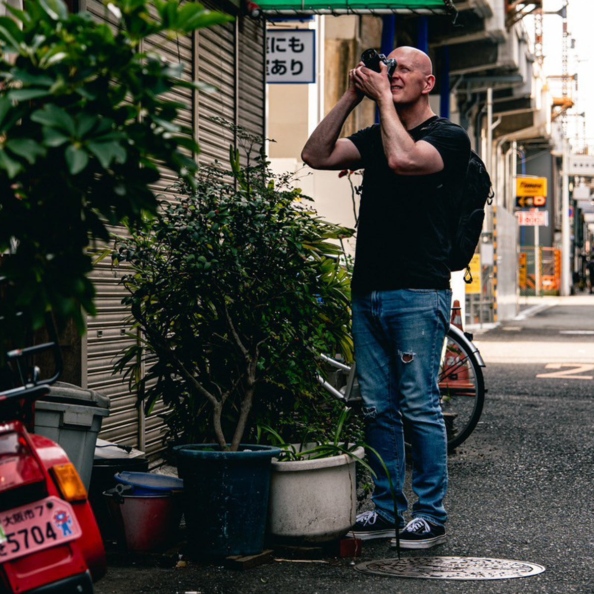 Chris Luckhardt taking a film photo in Osaka, Japan. Photo by @sanzyuyon.