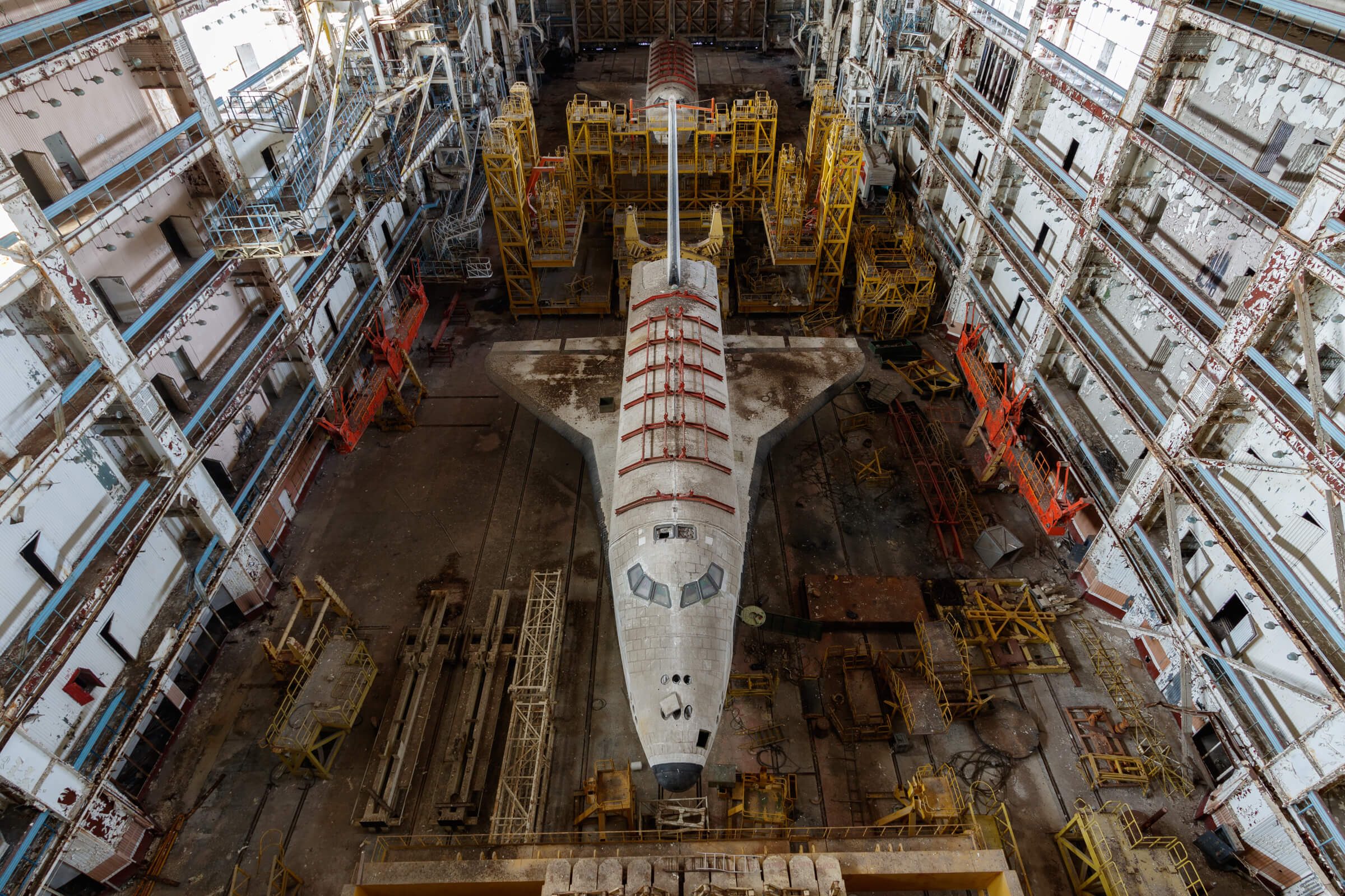 Abandoned Soviet Buran space shuttle resting inside the massive decaying MZK building in Kazakhstan.
